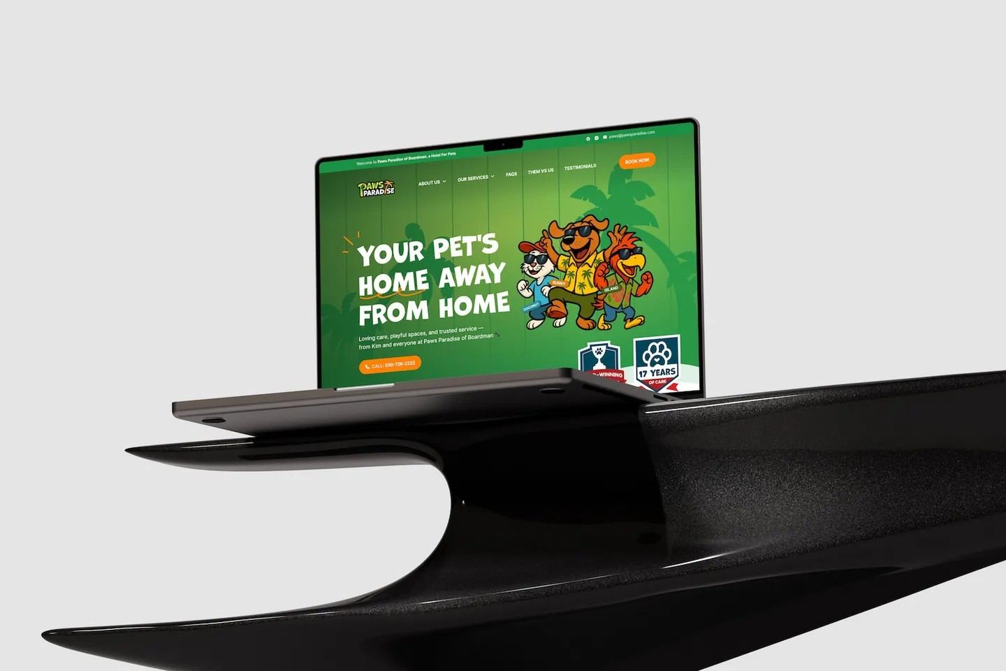 The Paws Paradise homepage on a laptop resting on a sleek black platform